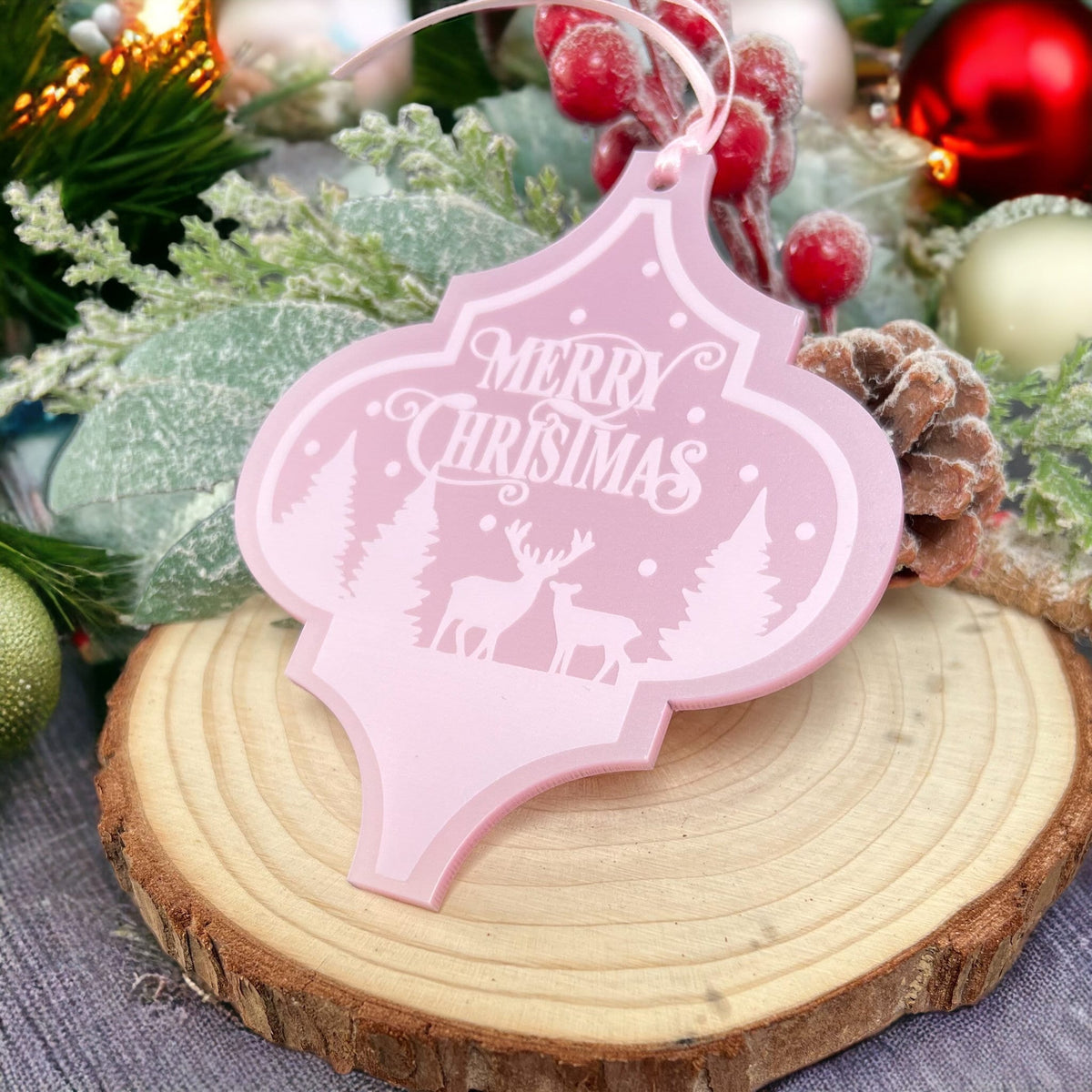 Close-up of the pearlised pink arabesque snow scene and deer design on the acrylic Christmas bauble