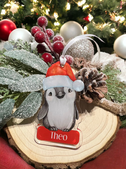Personalised Penguin acrylic bauble hanging on a Christmas tree branch