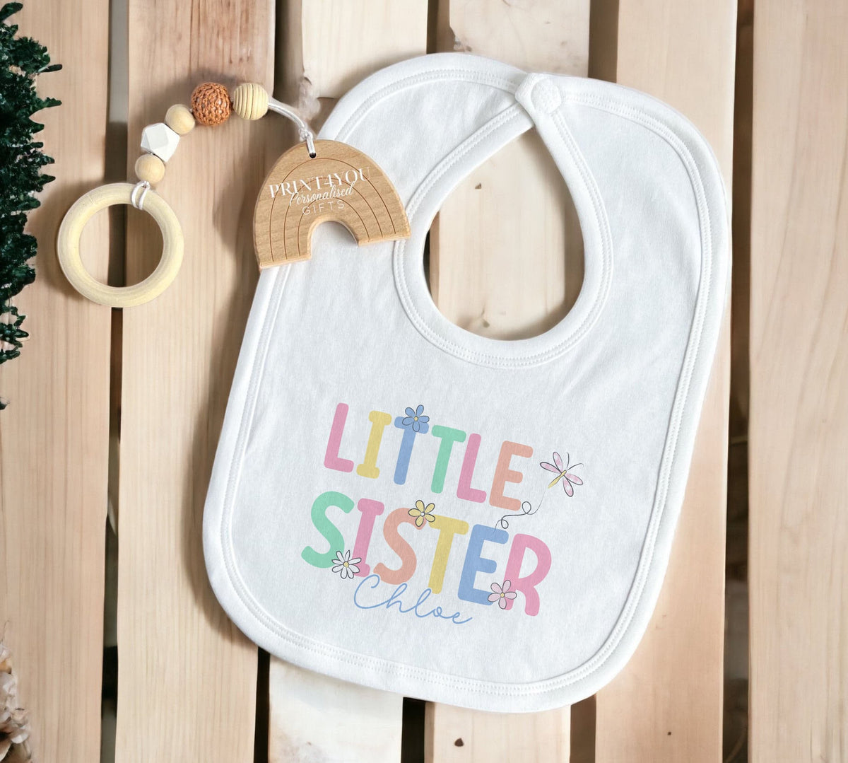 Close-up of the 'Little Sister' name print detail on the soft cotton fabric.