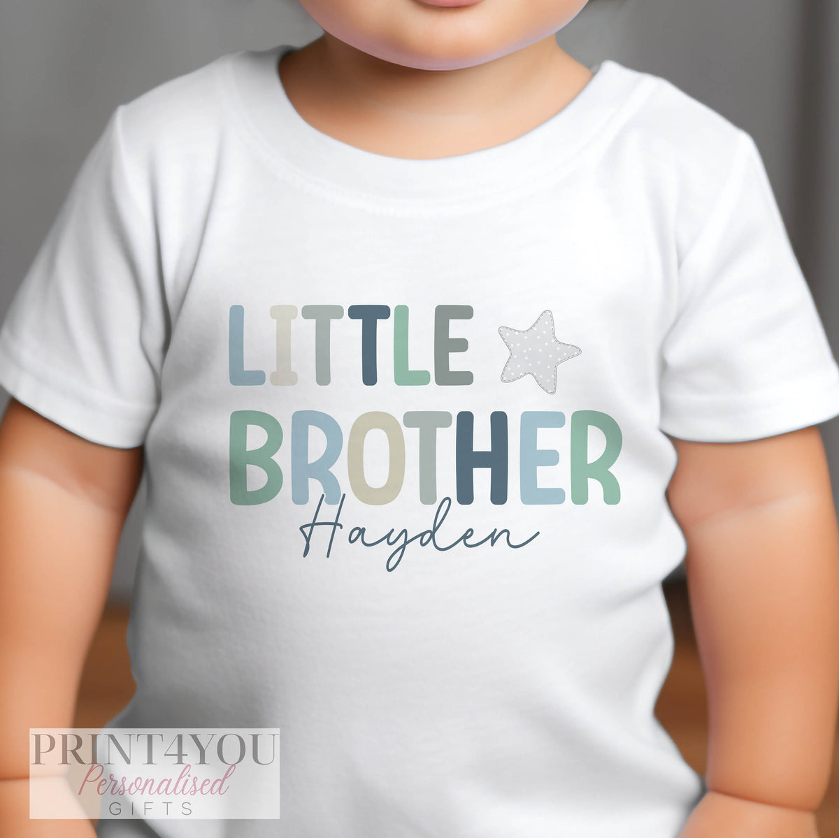 Close-up of the personalised 'Little Brother' print on soft cotton babywear.